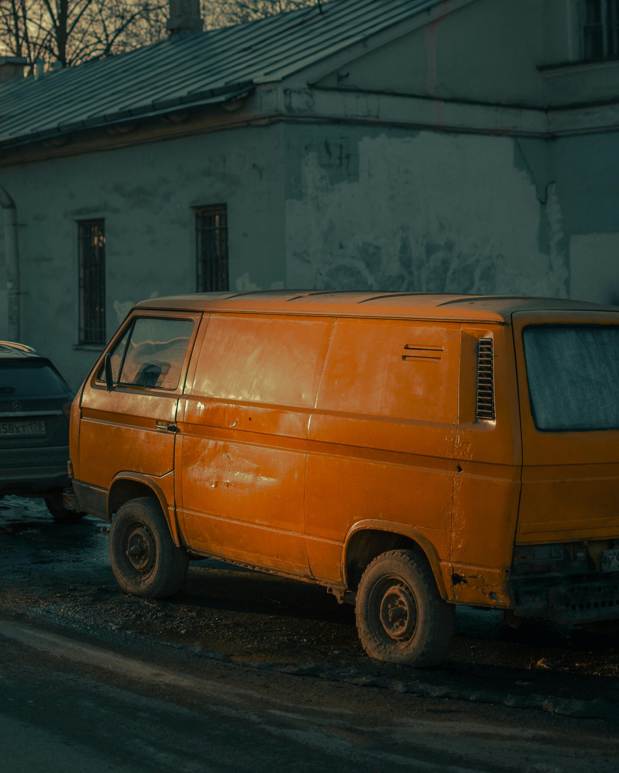 A classic yellow van parked in an urban street, evoking nostalgia and vintage charm.